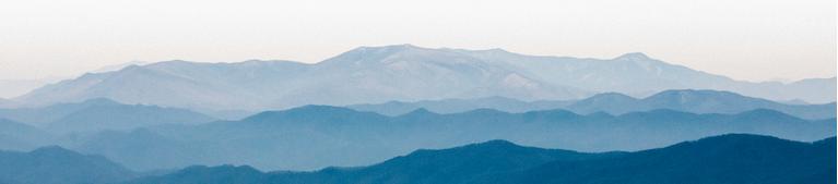 A scenic landscape print showing layered mountain ranges in shades of blue and gray fading into a pale sky.